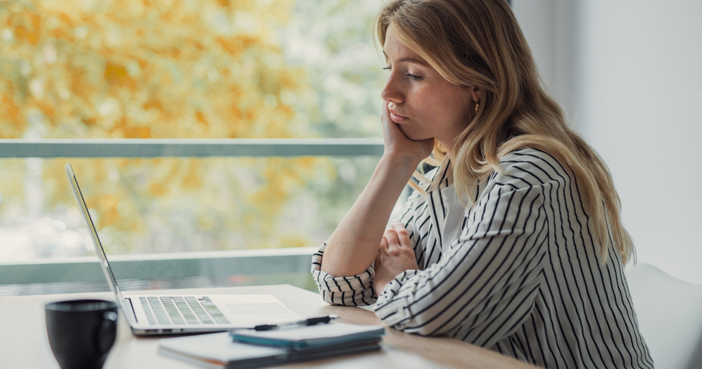 woman looking disappointed at her computer